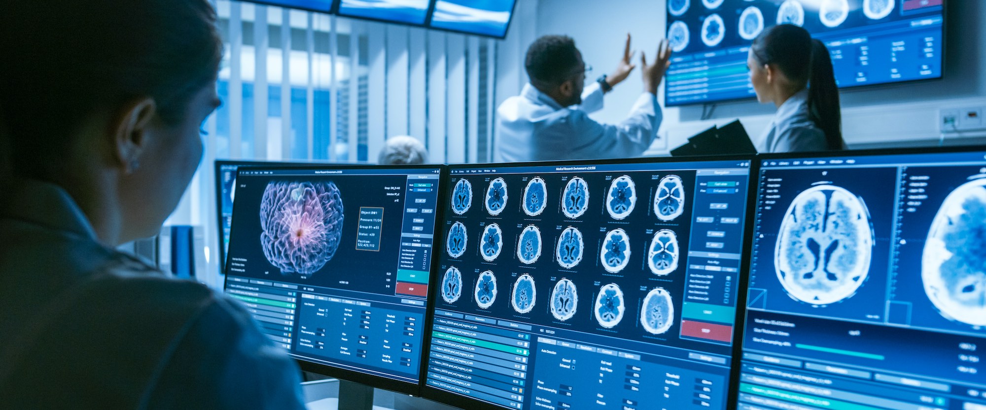 Medical professionals reviewing brain scans in a high-tech control room
